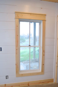 installing DIY shiplap walls and farmhouse trim from wood flooring