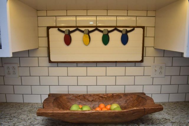 Our festive Christmas kitchen is full of sentimental holiday touches - including this holiday lights sign above a giant dough bowl.